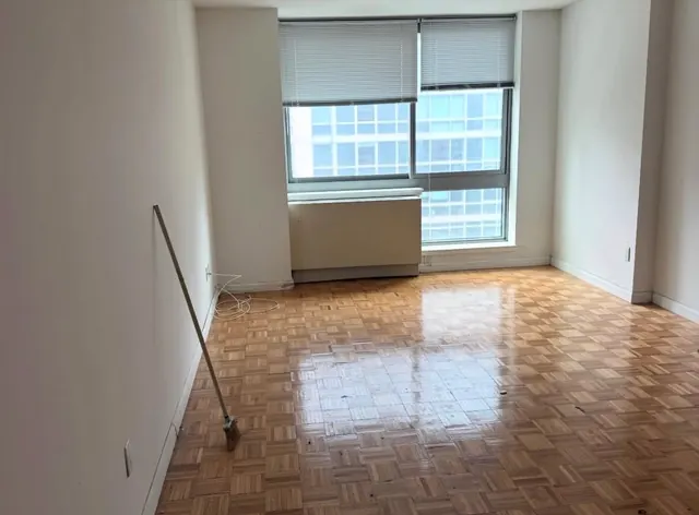 The same apartment after cleanout, empty with clean parquet floors